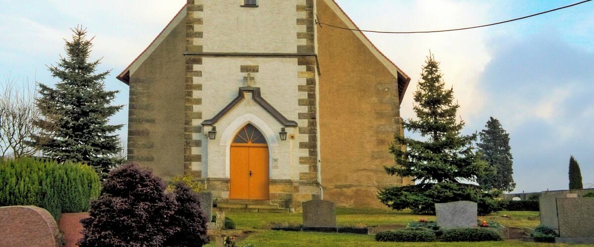 A church with a tall steeple and a clock.