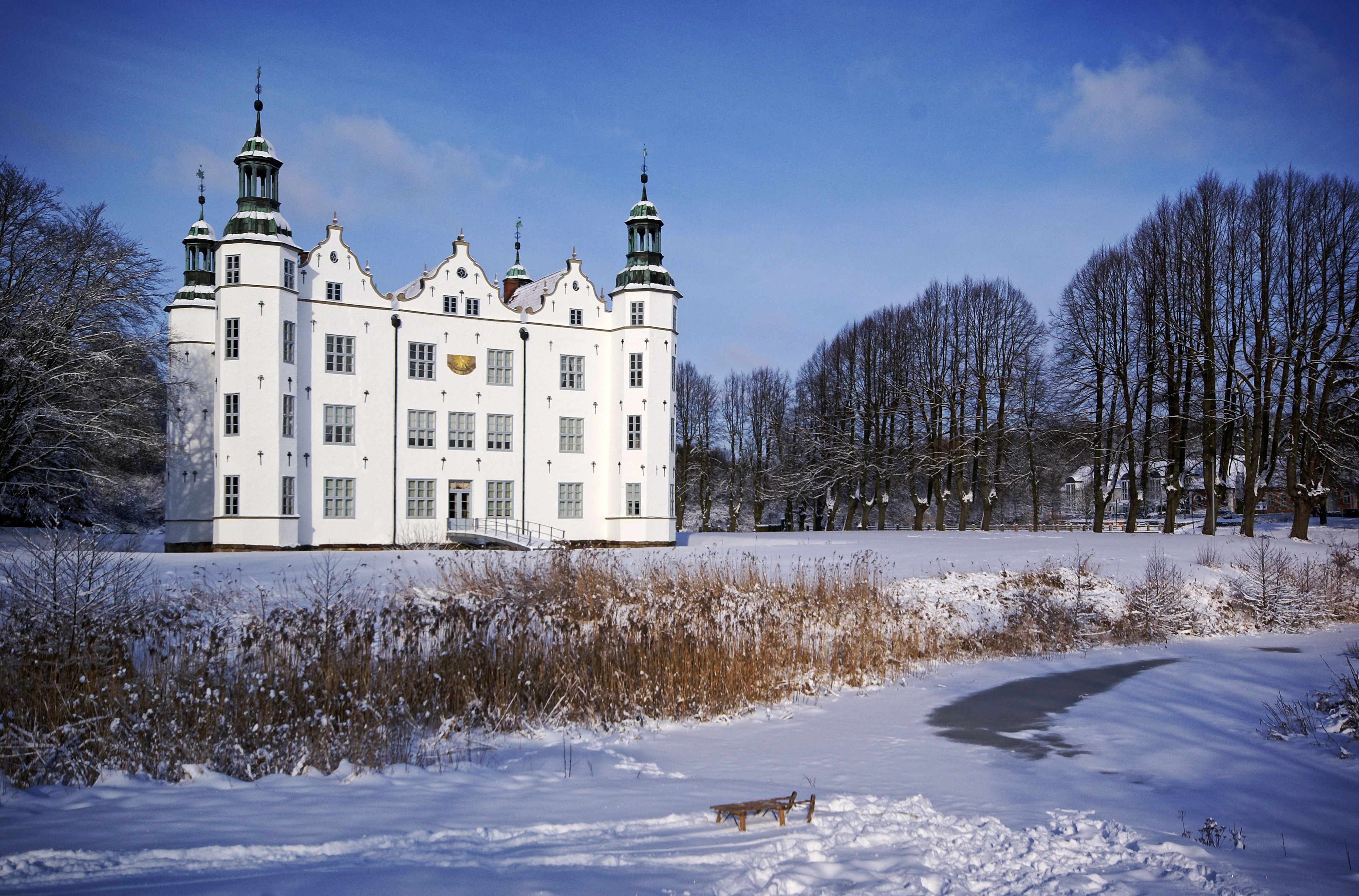 A large white building with multiple towers and a snow-covered landscape.