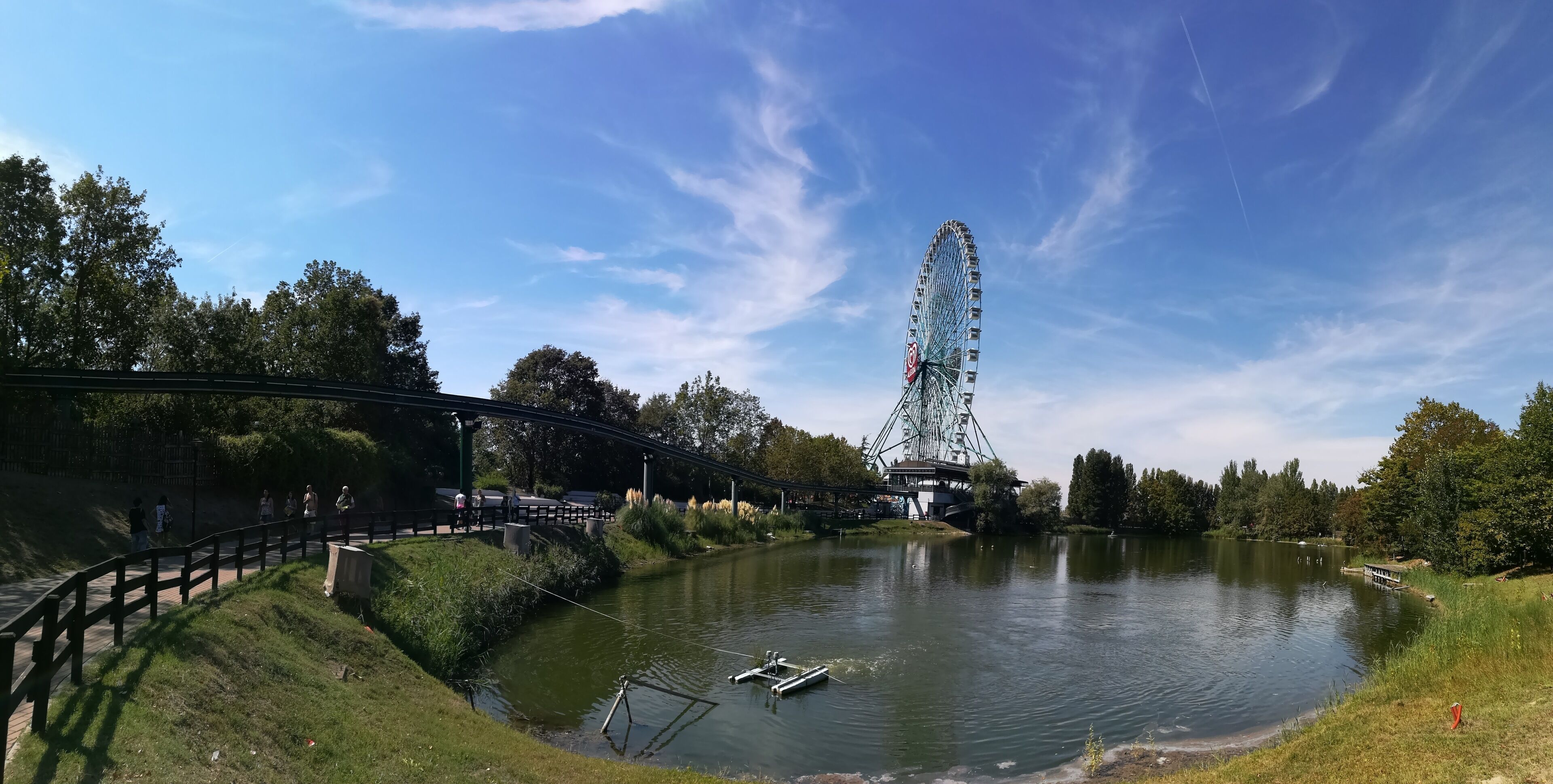 A Ferris wheel, a river, and a bridge.