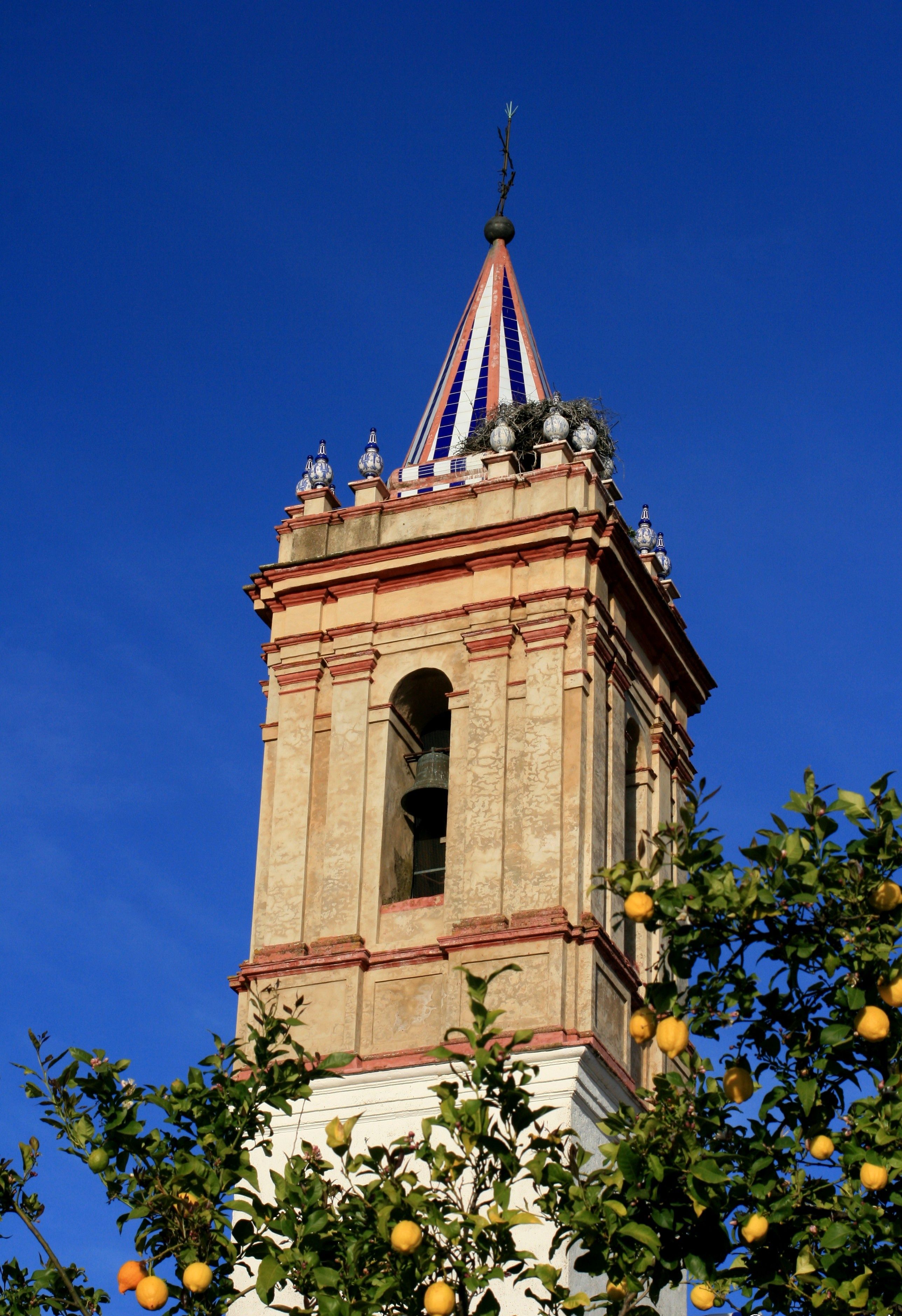 A tower with a pointed roof, a bell, and a spire.