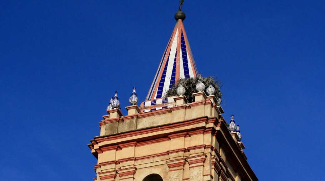 A tower with a pointed roof, a bell, and a spire.