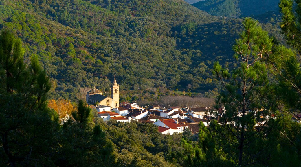 A village nestled in a valley with a prominent church and tower.