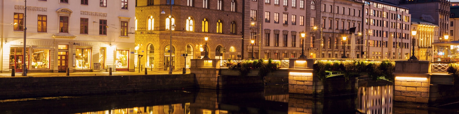 Vista nocturna de un río con edificios reflejados en el agua.