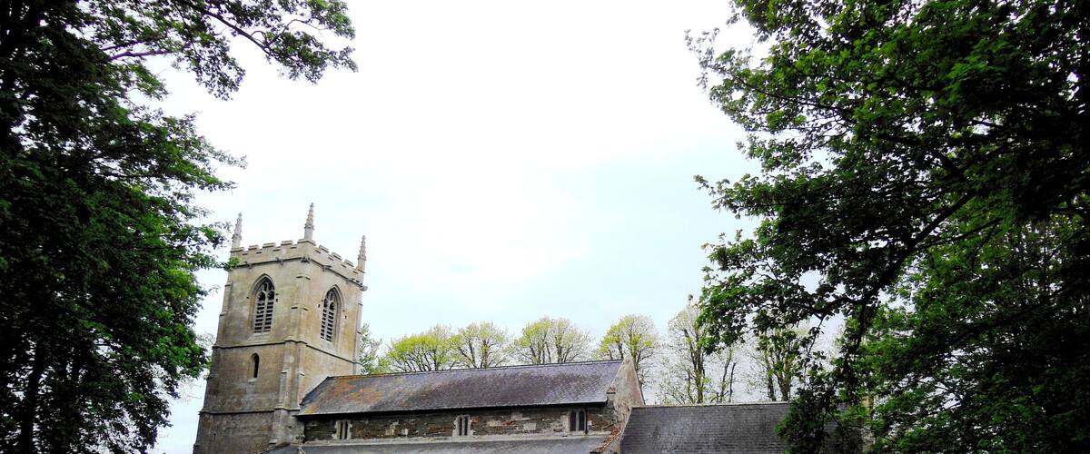 A historic church with a tall tower and a graveyard.