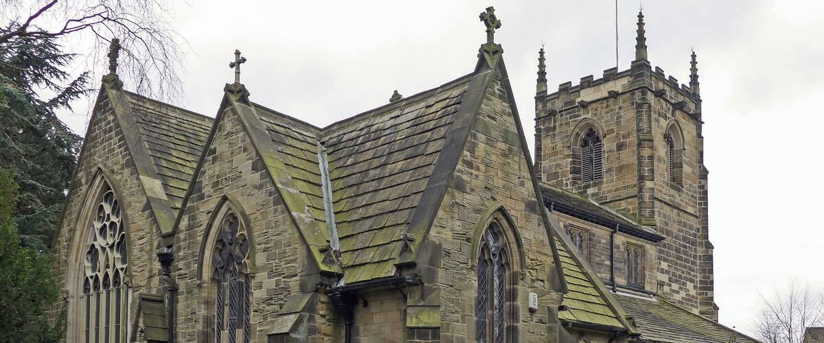 A historic church with a tall tower, pointed arches, and a stone facade.