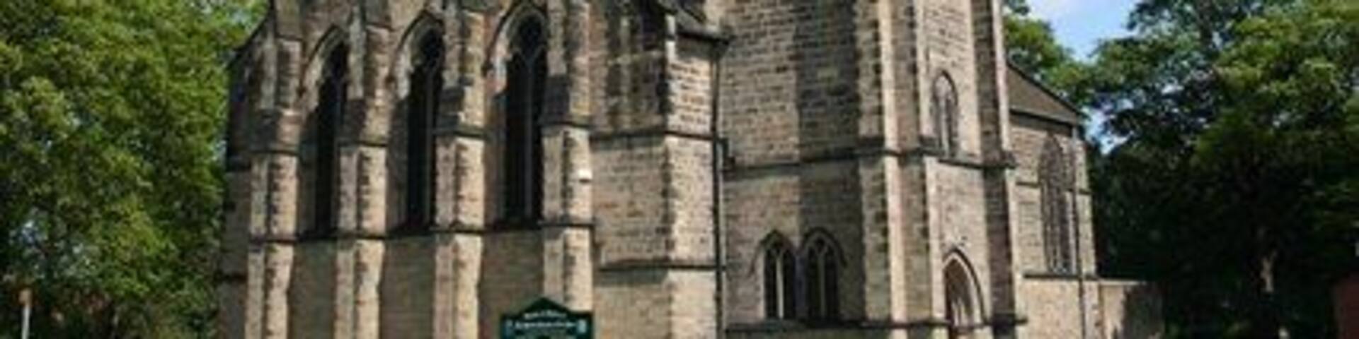A church with a tall steeple and two clocks.