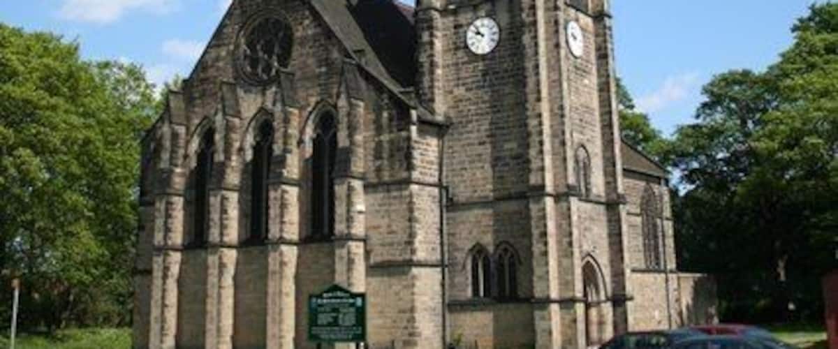A church with a tall steeple and two clocks.