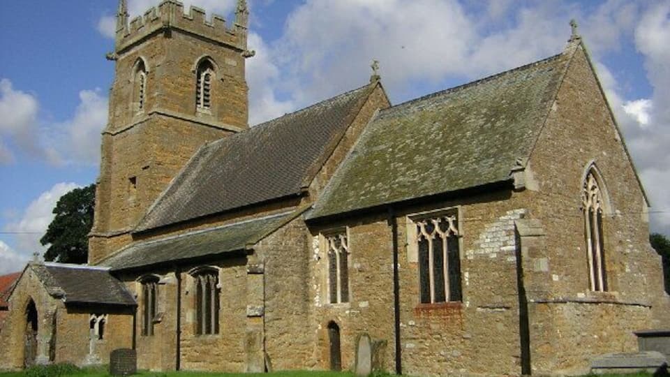 A historic church with a prominent tower and arched windows.