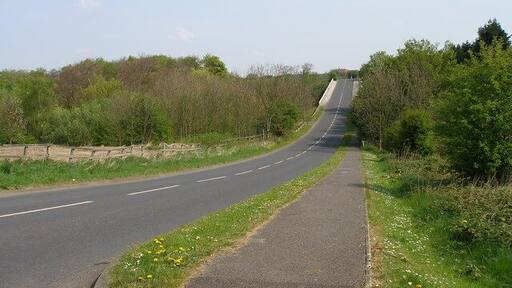 Pilley Lane This quiet road cut through lovely countryside. The white edges to the lane at the top of the picture are the bridge parapet as it passes over the M1.