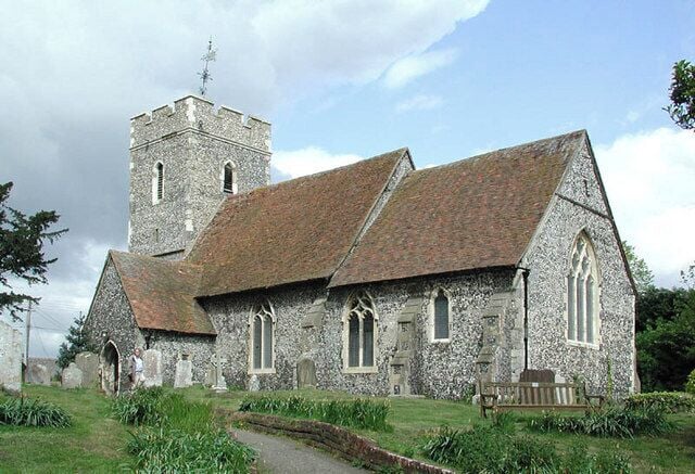 A stone church with a tower and arched windows.