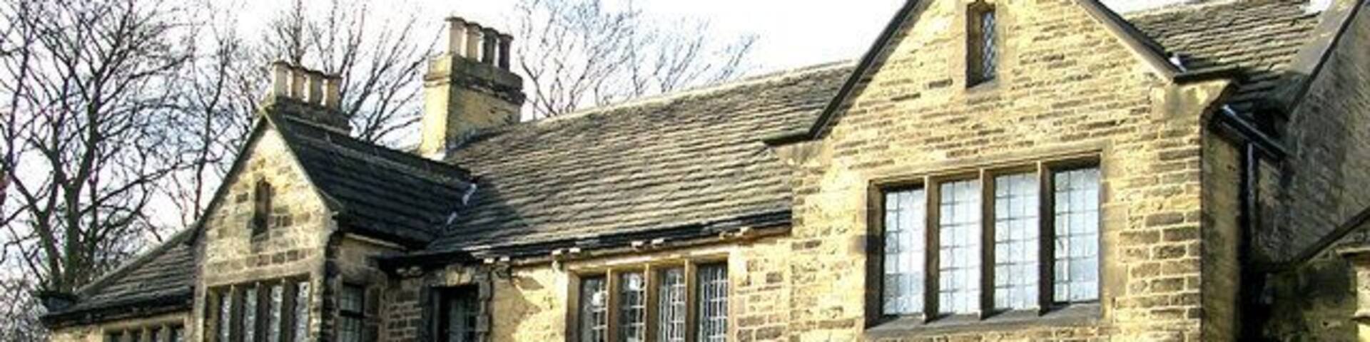 A large stone house with multiple windows and a balcony.
