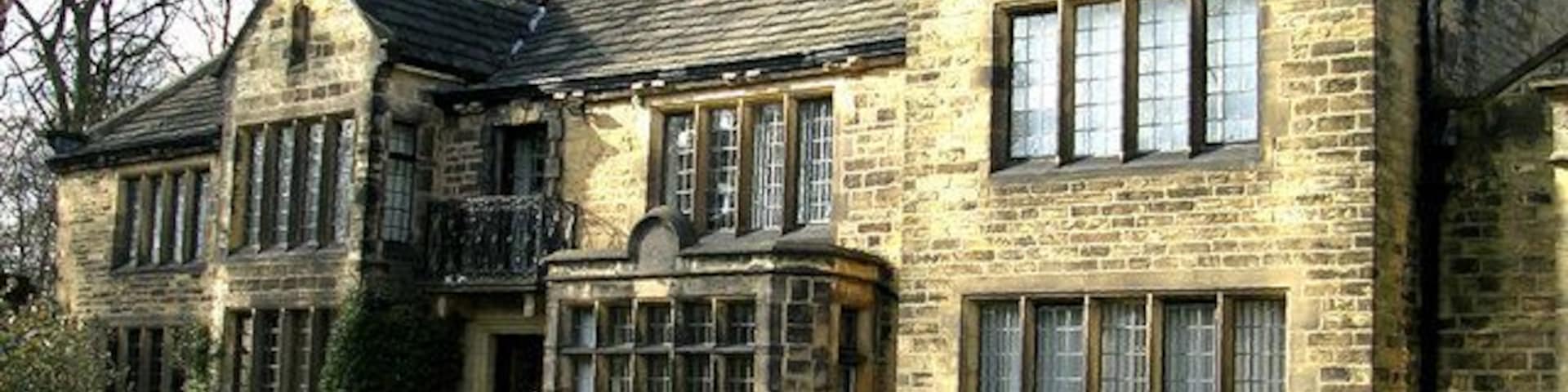 Una casa grande de piedra con varias ventanas y un balcón.