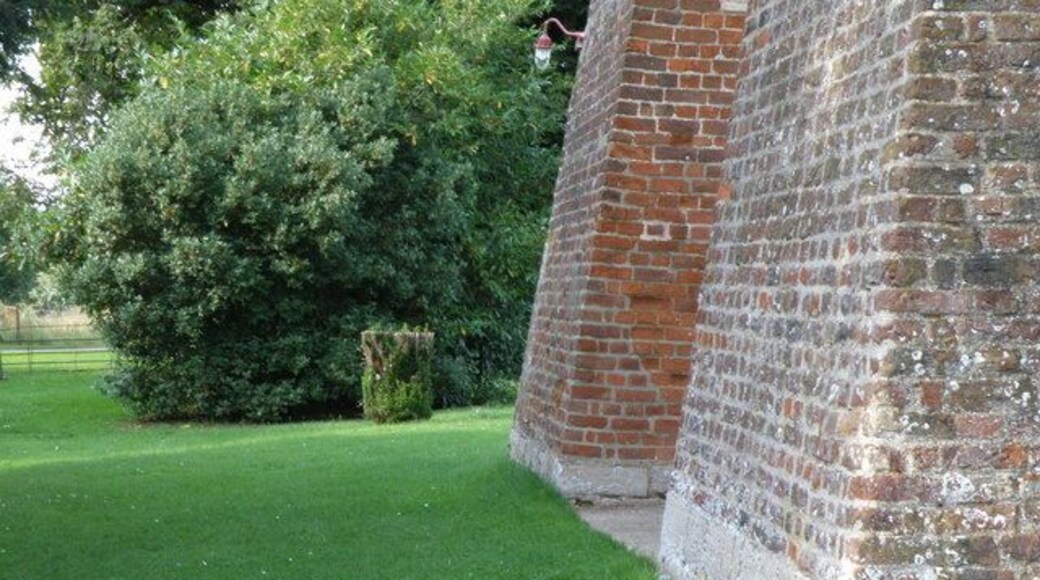 The feet of two of the buttresses of the west tower of St Mary's parish church, Conington, Cambridgeshire. An Ordnance Survey bench mark is visible on the nearer buttress.