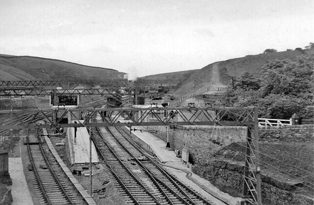 Un andén ferroviario con múltiples vías y una estructura de puente.