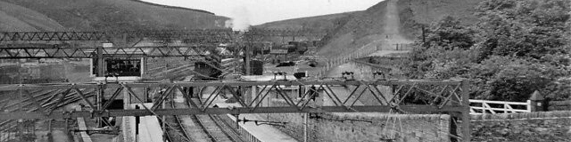 Un andén ferroviario con múltiples vías y una estructura de puente.
