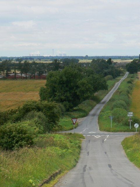 Crossroad, Hotham, East Riding of Yorkshire, England. Looking down Common Hill and toward Carr Lane on the opposite side of the crossroads. Cliffe Road runs across the picture. The power station on the skyline is Drax.