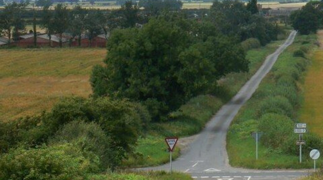 Crossroad, Hotham, East Riding of Yorkshire, England. Looking down Common Hill and toward Carr Lane on the opposite side of the crossroads. Cliffe Road runs across the picture. The power station on the skyline is Drax.