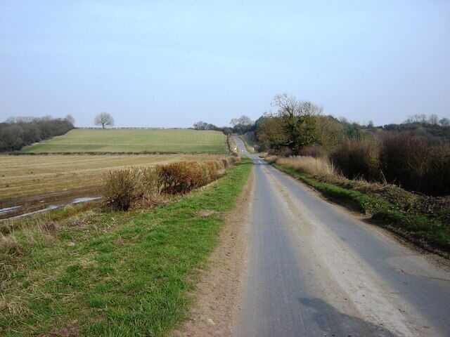 Lane from Hotham Carr toward Hotham, East Riding of Yorkshire, England. Road Signs at the bottom of the hill mark the Cliffe Road junction. The rising land is the start of the Yorkshire Wolds.