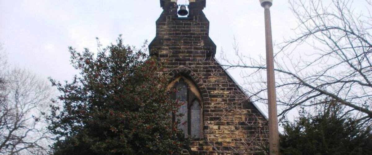 A stone church with a bell tower and a large arched entrance.