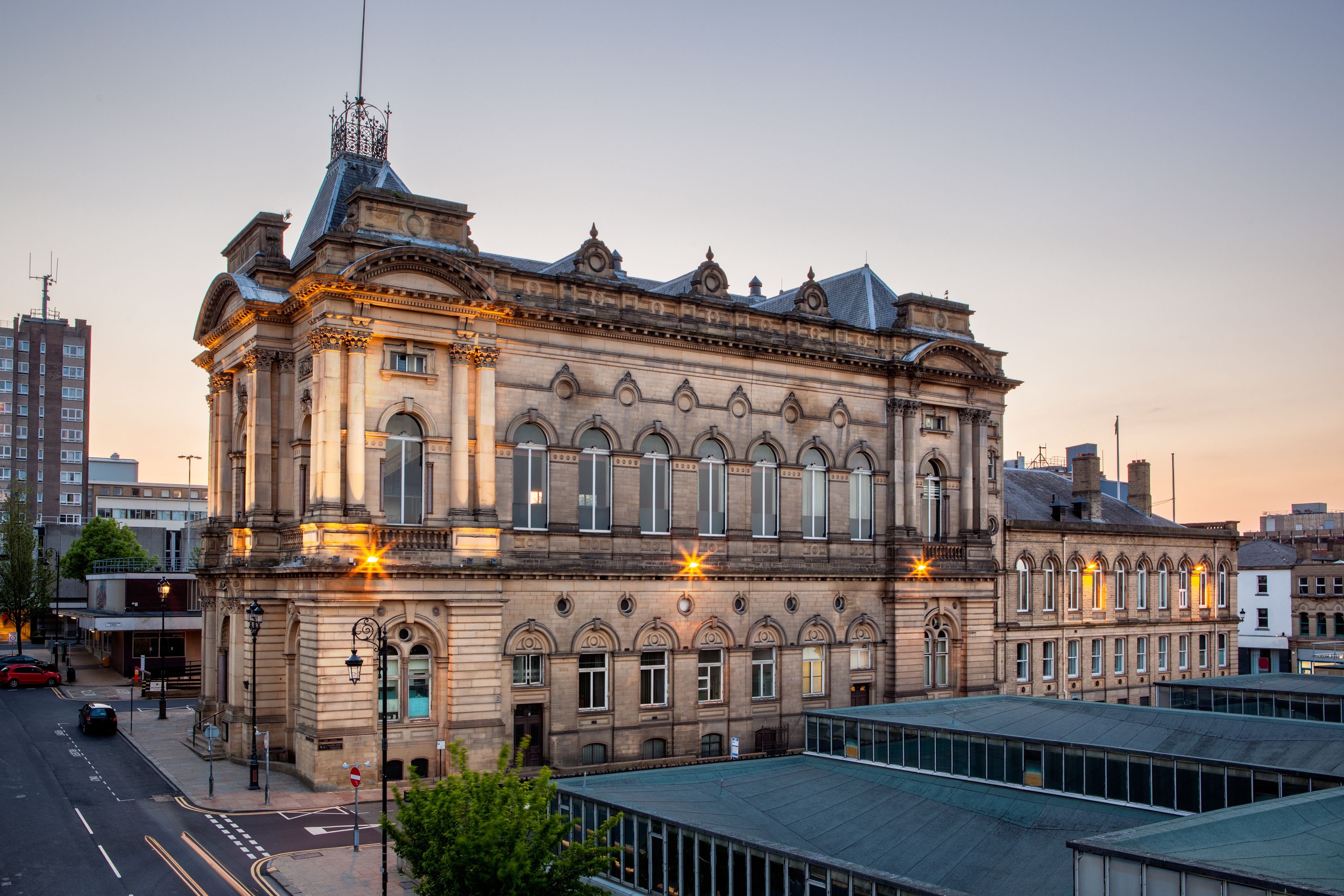 A historic building with ornate architectural details, large windows, and a prominent tower.