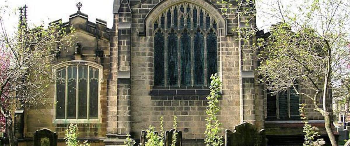 A Gothic-style church with a large arched window and a stone facade.