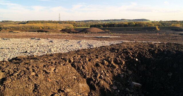 A barren landscape with rocky terrain and piles of earth.