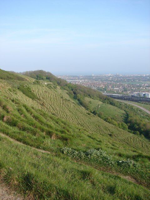 Folkestone To Etchinghill Escarpment Taken from Crete Road West, looking over the chalk escarpment, with Eurotunnel and Folkestone in the foreground. This area is designated SSSI and SPA, due to being one of the largest areas of unimproved chalk grassland in Kent.