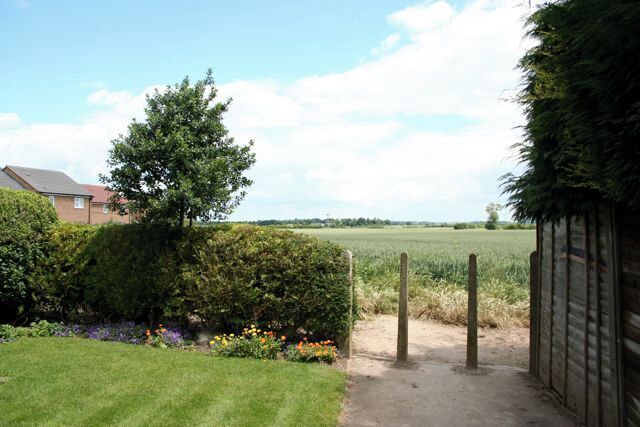 Town meets country Neat lawns and tidy bungalows sit on the very edge of farm land, separated by a hedge, some colourful flowers and four bollards. Urban and rural lines are clearly drawn.