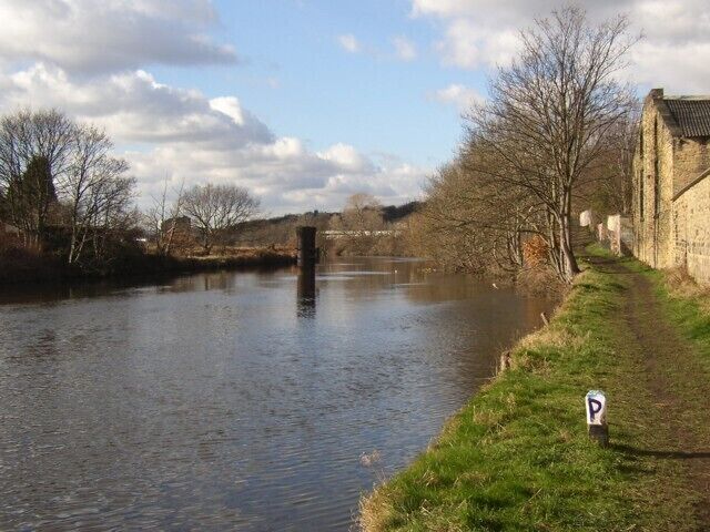 Towpath alongside the River Calder, Mirfield (SE200198) The river here is part of the Calder and Hebble Navigation. The towpath, now a public footpath, used to cross the river by a toll bridge, the central cast-iron piers of which can be seen in the middle of the photo.
