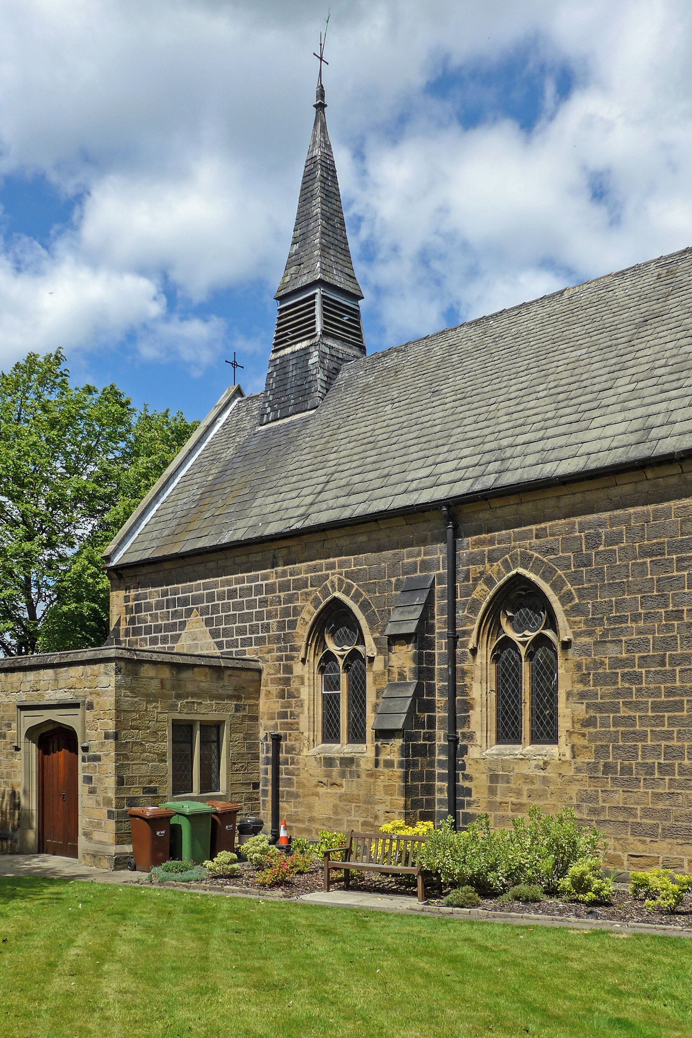 A stone church with a pointed steeple and arched windows.