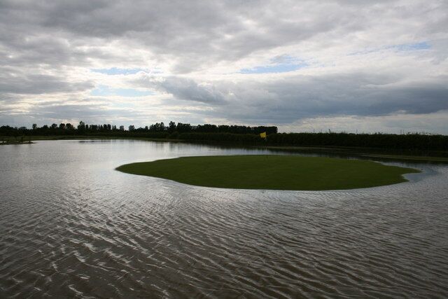 A large body of water with a small green island in the center.