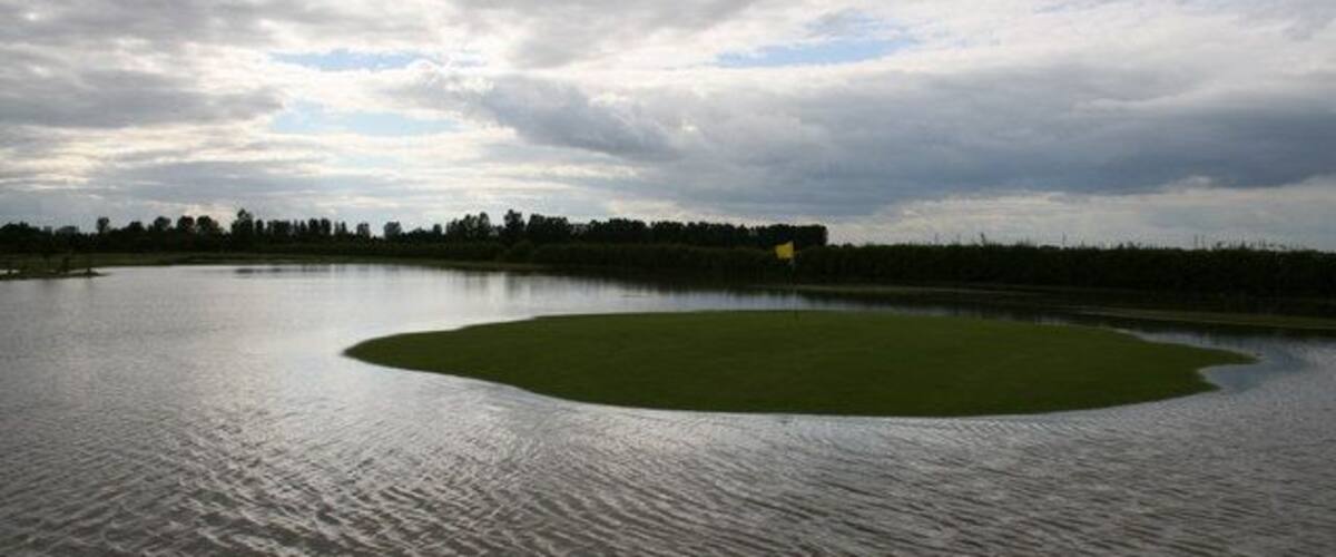 A large body of water with a small green island in the center.