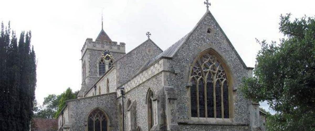 A historic stone church with a prominent tower and large arched windows.