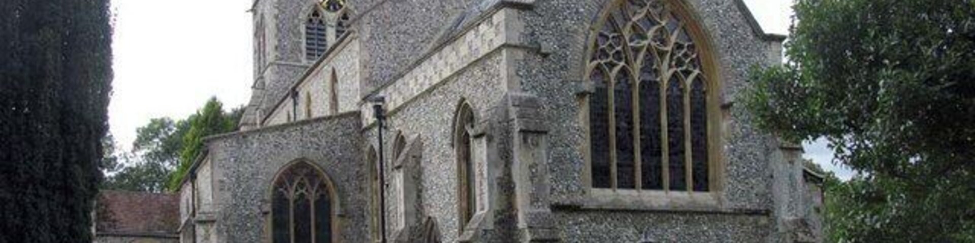 A historic stone church with a prominent tower and large arched windows.
