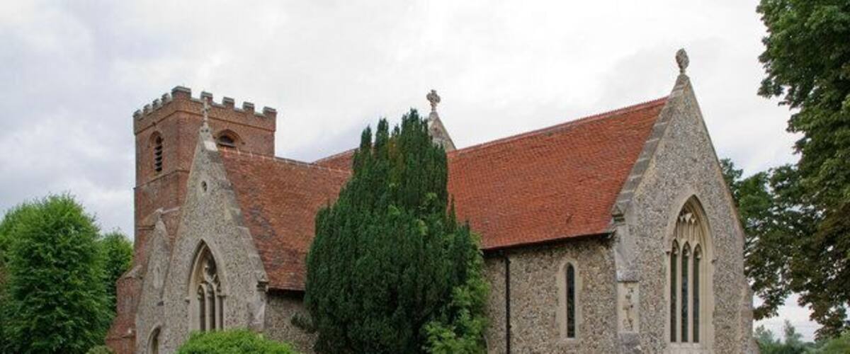 A historic church with a tall tower, a pointed roof, and a stone facade.