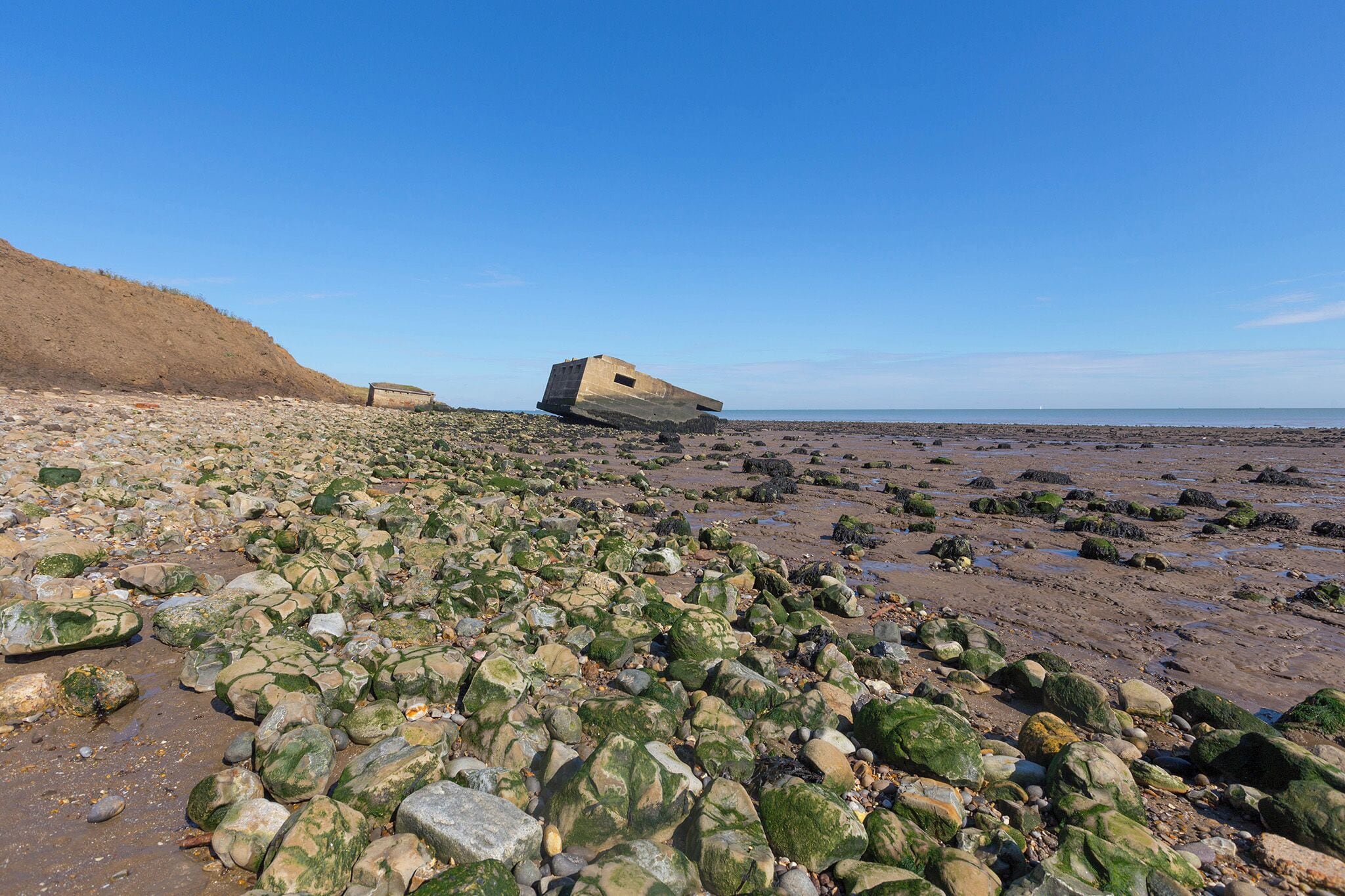A rocky beach with a tilted structure.