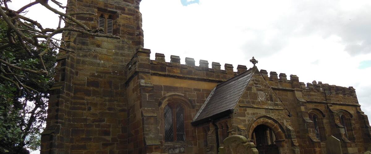 A stone church with arched windows and a bell tower.