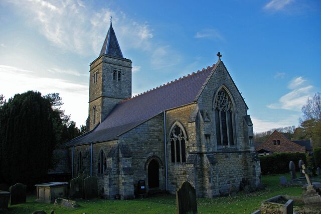 A stone church with a tall tower and arched windows.