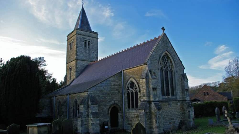 A stone church with a tall tower and arched windows.