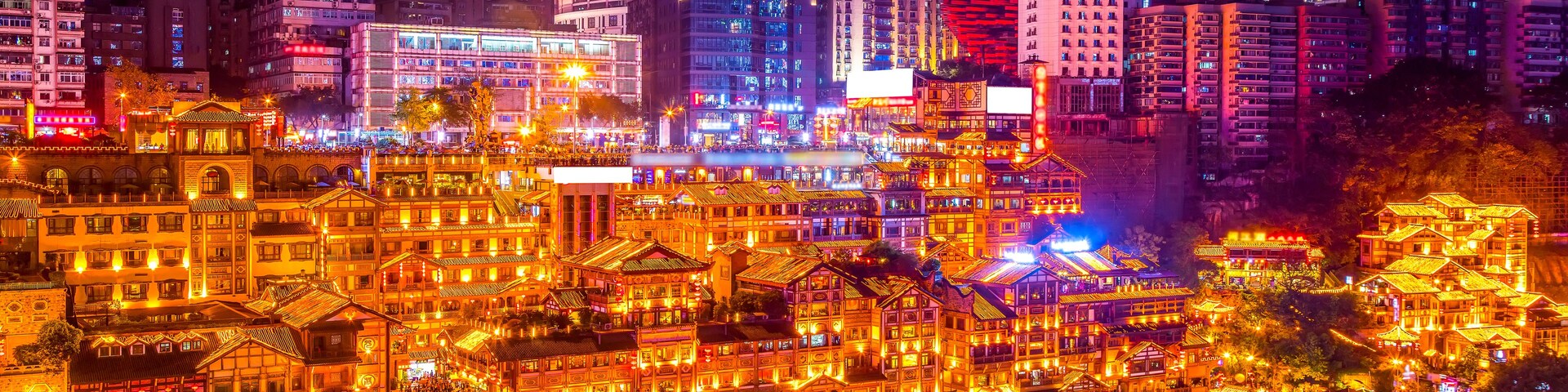 Un paisaje urbano nocturno con rascacielos iluminados y edificios tradicionales.