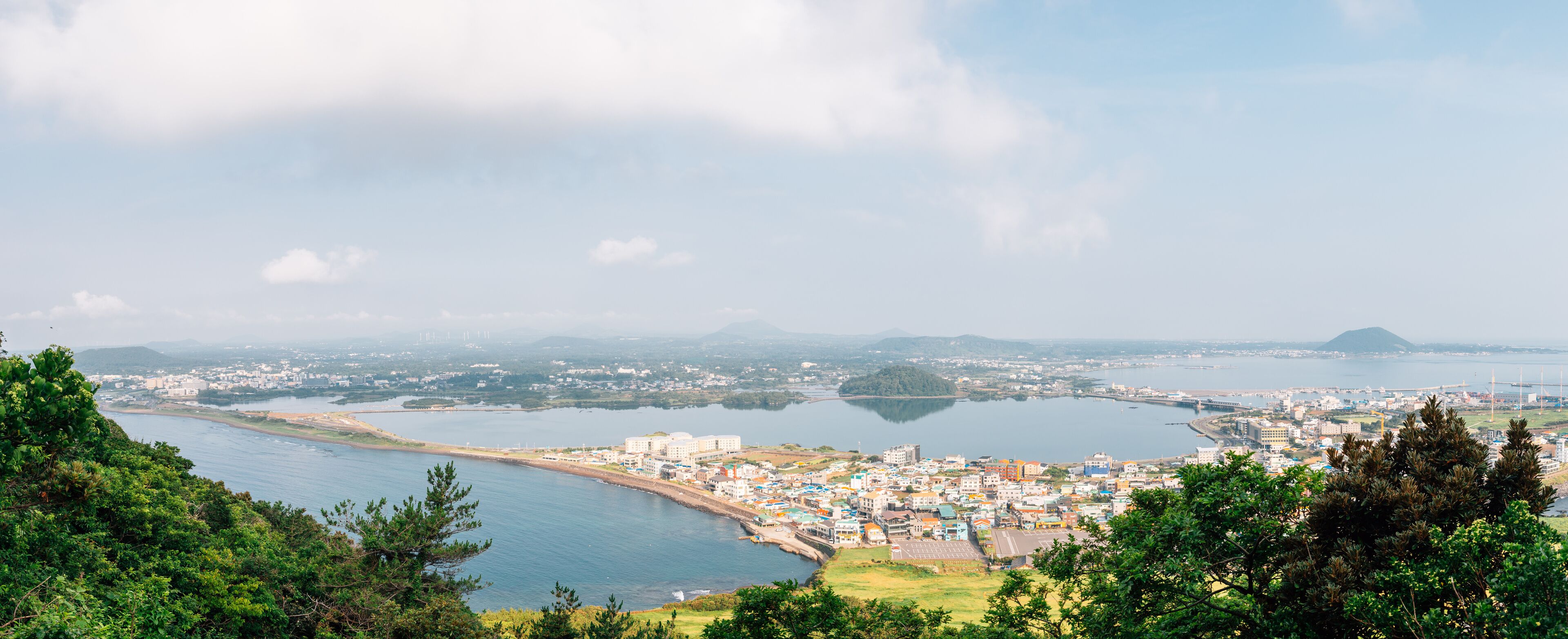 Panoramic view of sea and city from Seongsan Ilchulbong Tuff Cone in Jeju Island, Korea