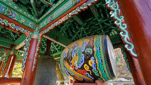 Bronze bell and painted drum in highly decorated pavilion at Magoksa Buddhist temple, Gonju, South Korea
