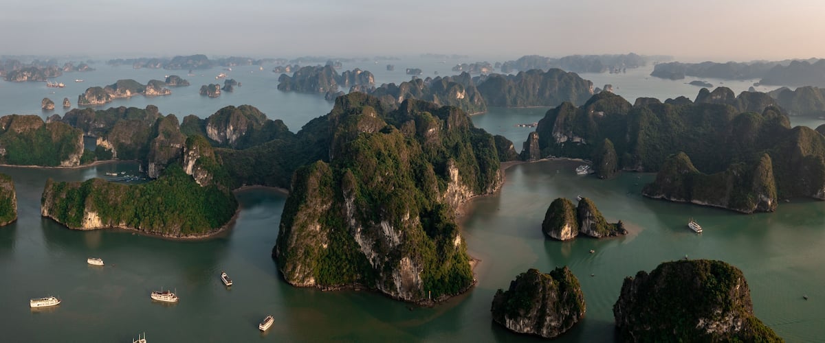 A coastal landscape with numerous limestone islands surrounded by water.