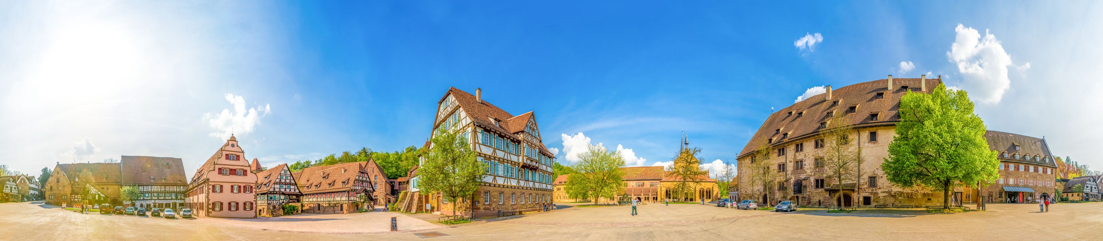Vista panorámica de una plaza histórica con edificios tradicionales de entramado de madera y una iglesia.