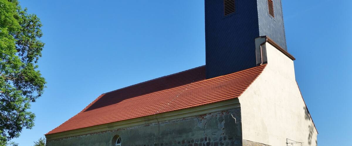A church with a red roof and a blue tower.