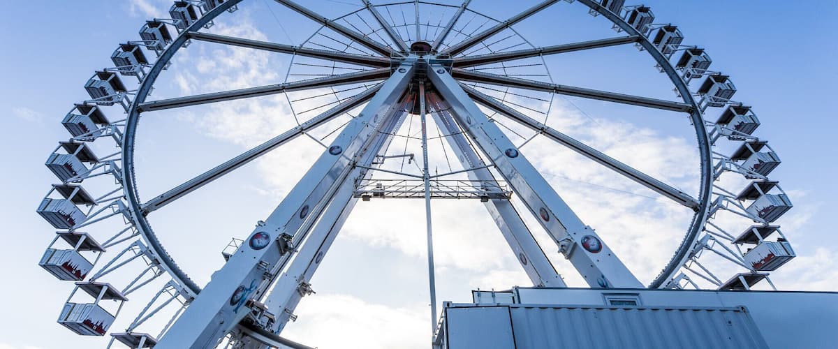 A large Ferris wheel with multiple cabins against a clear blue sky.