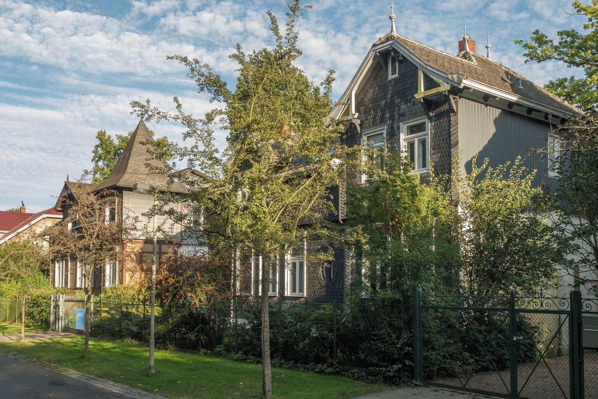 A row of traditional houses with steep roofs and a well-maintained garden.