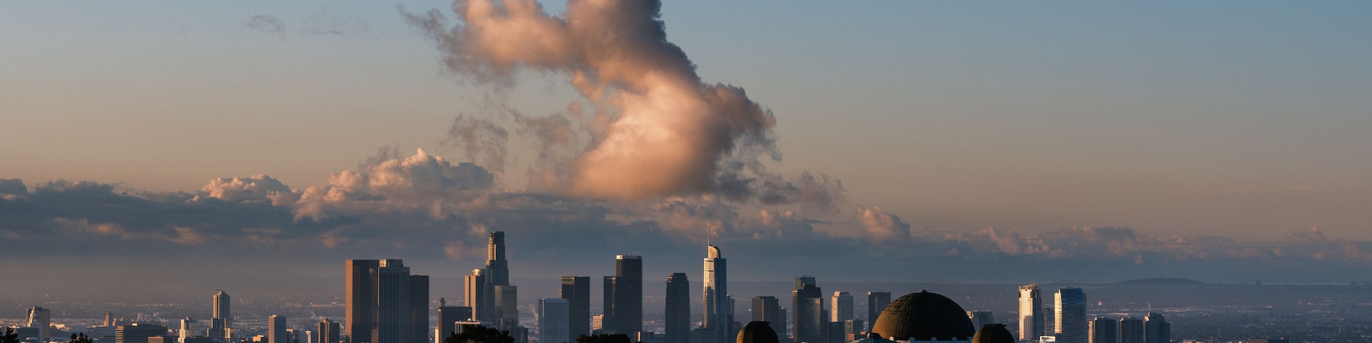 A city skyline with prominent skyscrapers and a large dome structure.
