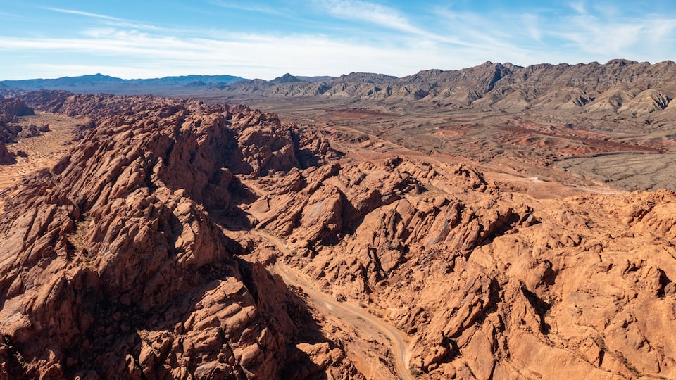 A rugged mountainous landscape with a winding dirt road.