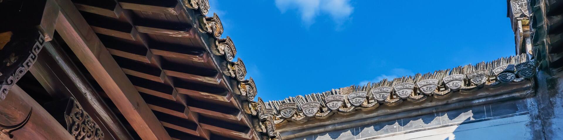 A traditional roof with ornate tiles and a wooden structure.